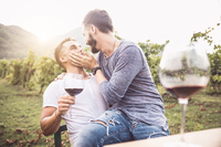 Küssendes Paar beim Wein trinken
